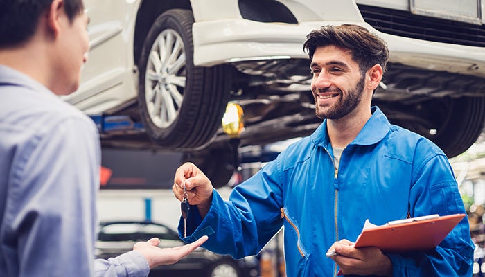 service technician handing custom car key